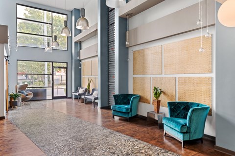 A room with blue chairs and a rug.