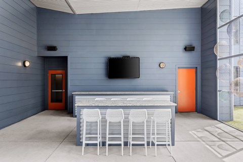 A kitchen with a bar and chairs.