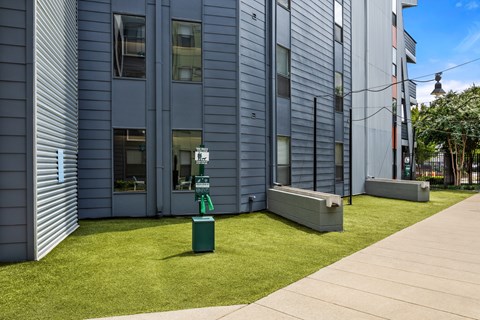 A modern building with a green trash can in front of it.