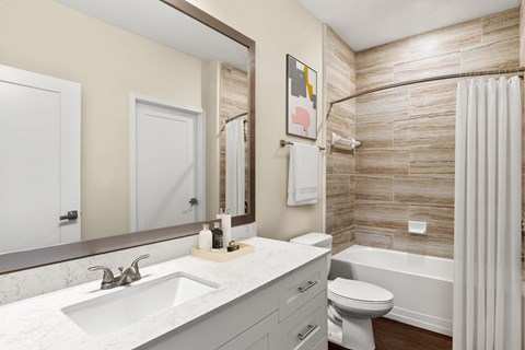 A bathroom with a sink, toilet, and bathtub.