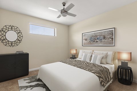 A bedroom with a large bed, a ceiling fan, and a decorative wall art.