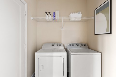 Two white front loading washing machines in a laundry room.