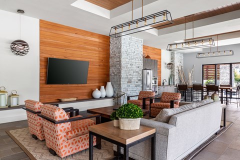 A modern living room with a wooden wall and a grey couch.