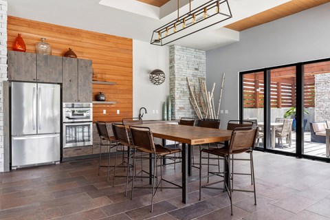 A kitchen with a wooden wall and a table with chairs.