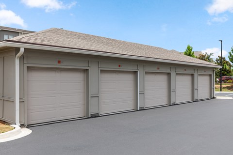A building with grey garage doors and a brown roof.
