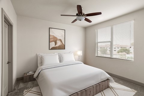 A bedroom with a large bed and a ceiling fan.