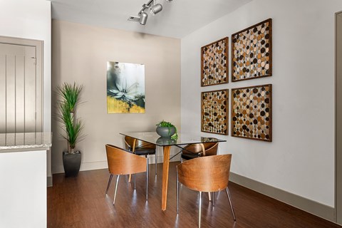 A dining room with a glass table and chairs.