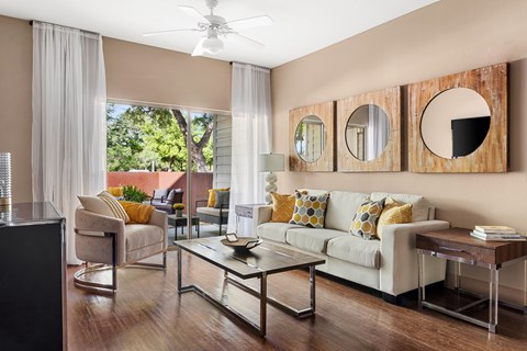 A living room with a white couch and a glass coffee table.