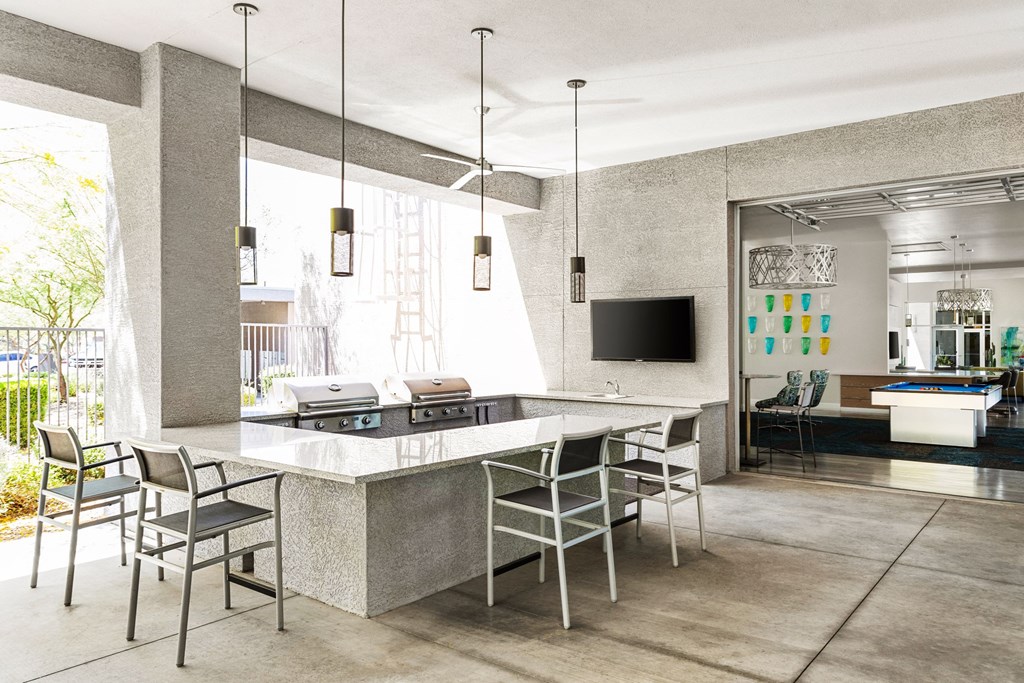A modern kitchen with a large island and chairs.