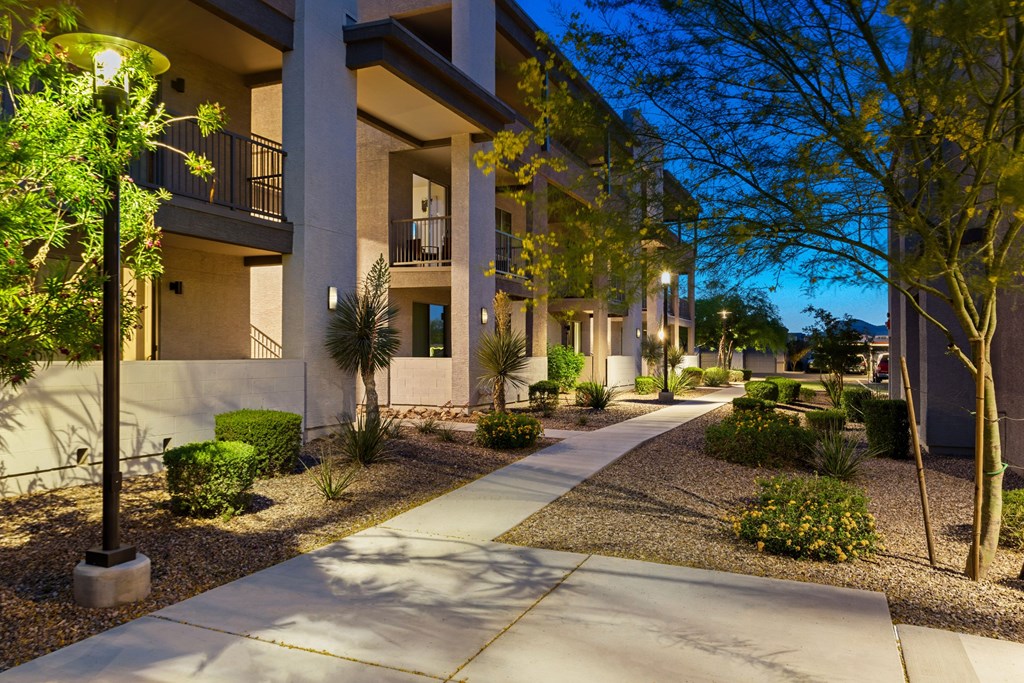 A sunny day in a residential area with apartment buildings and a sidewalk.