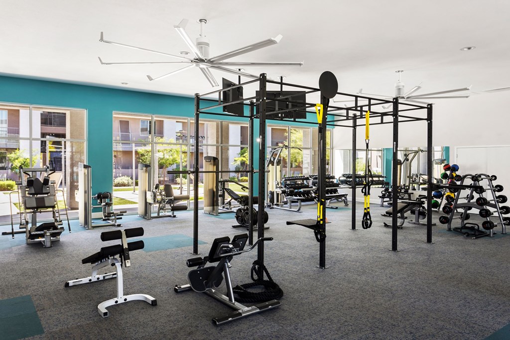 A gym with a variety of equipment including weights and cardio machines.