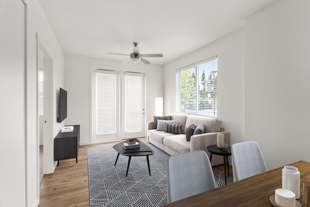 A living room with a couch, chairs, and a television.