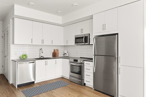 A modern kitchen with stainless steel appliances and white cabinets.