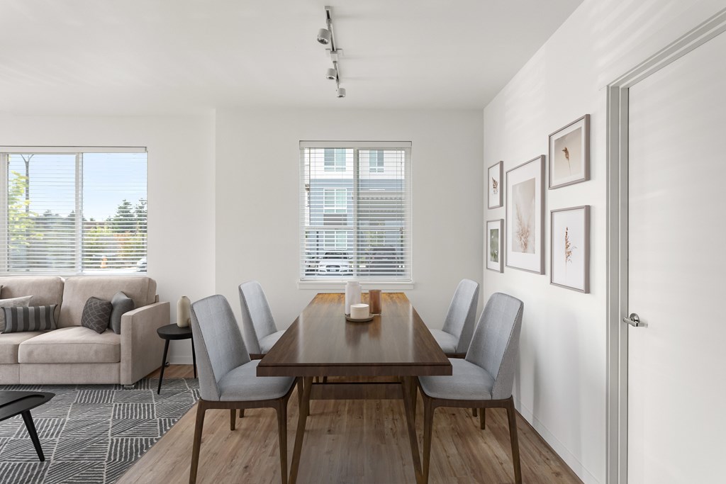 A dining room with a wooden table and grey chairs.
