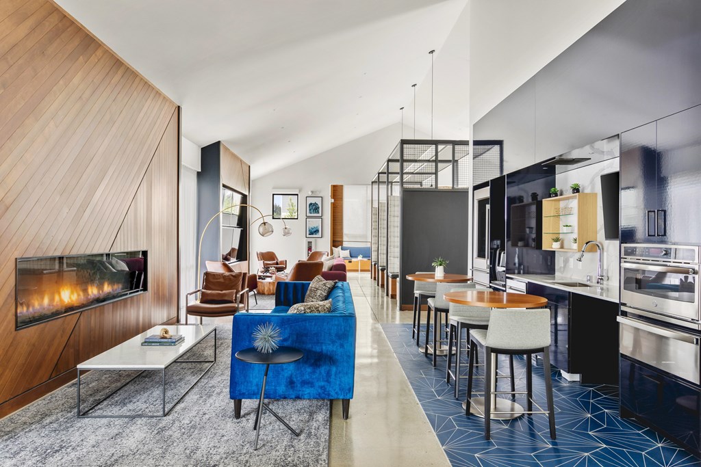 A modern living room with a fireplace and a blue couch.