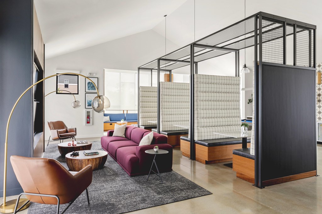 A living room with a purple couch and a black and white striped wall.