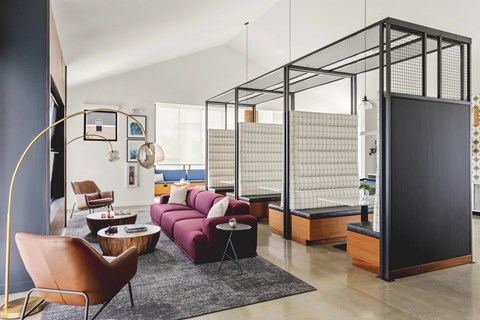 A living room with a purple couch and a black and white striped wall.
