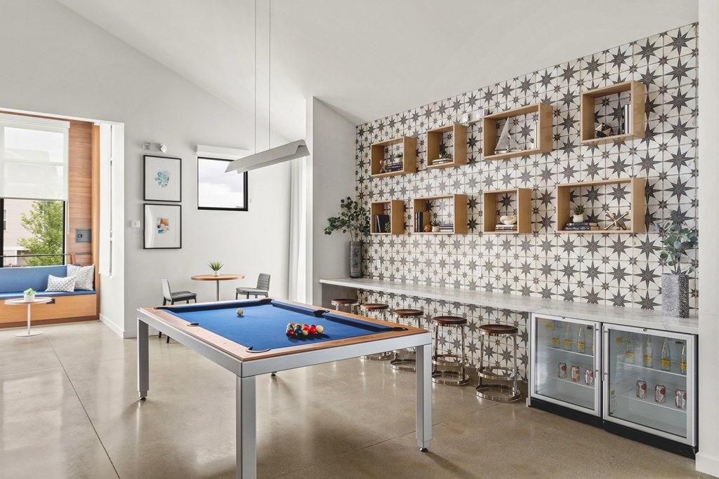 A pool table in a room with a wallpapered wall.