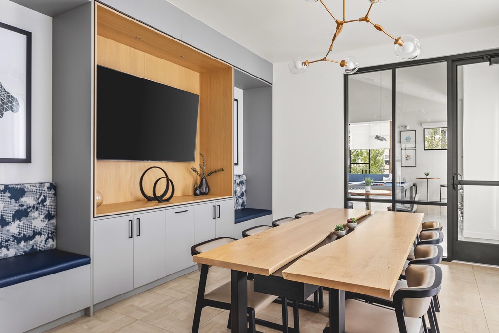 A modern dining room with a wooden table and chairs.