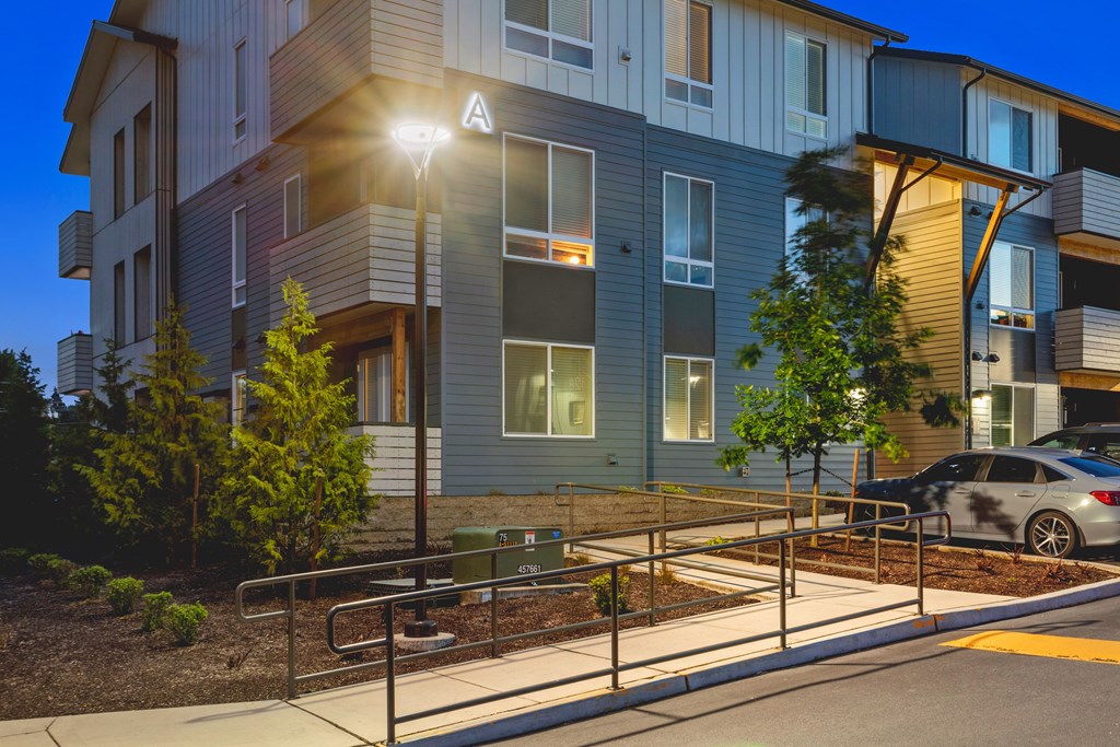 A modern apartment building with a car parked in front.