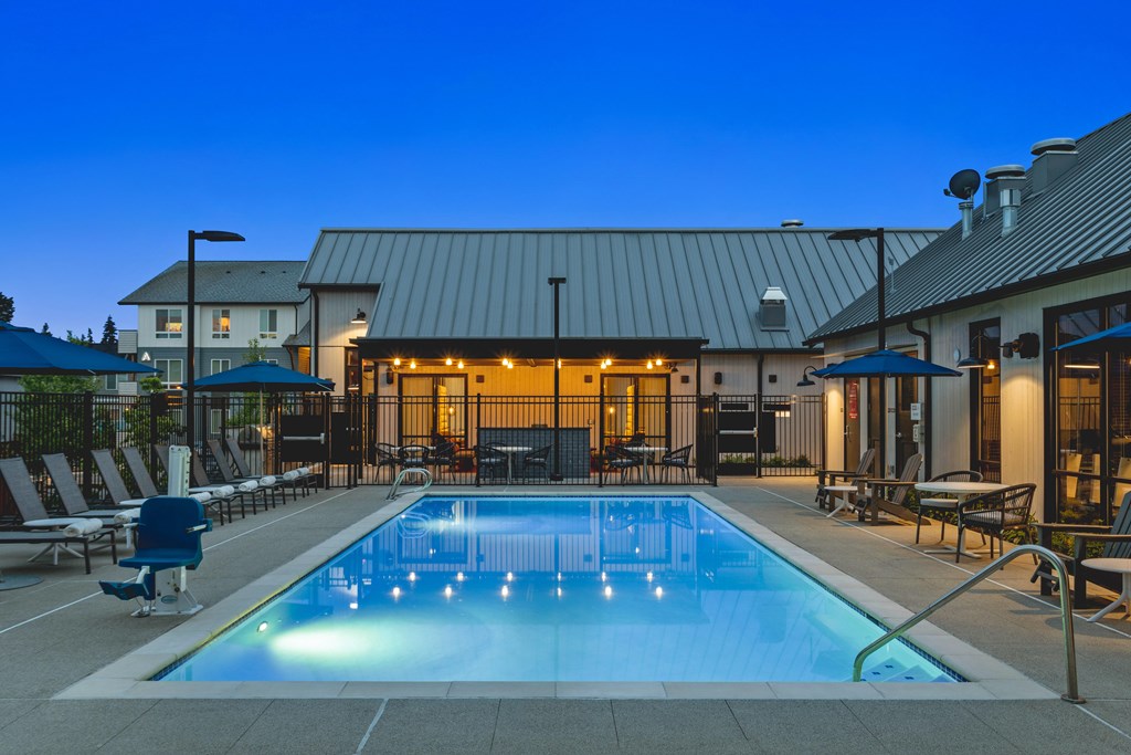 A swimming pool in a backyard with a building in the background.