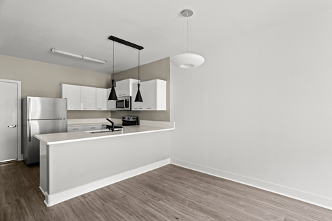 A kitchen with a white counter and a refrigerator.