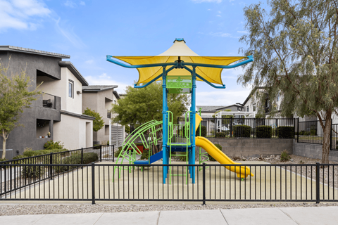 A playground with a blue and yellow slide and a yellow canopy.