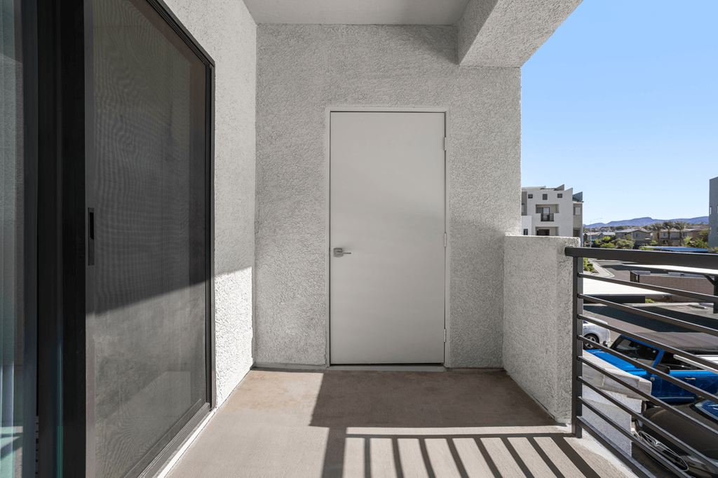 A white door is on the side of a building.