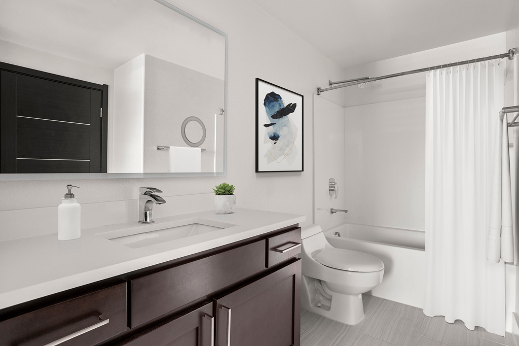 A bathroom with a white sink and a white toilet.