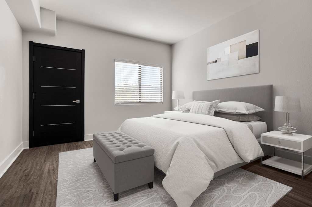 A modern bedroom with a large bed, a black wardrobe, and a white nightstand.