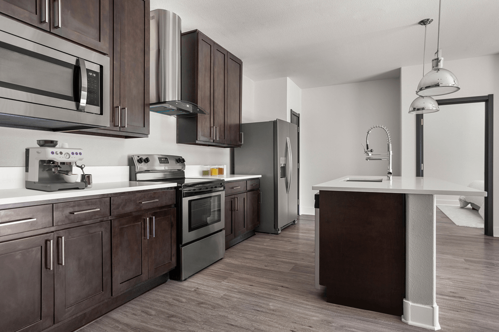 A modern kitchen with dark wood cabinets and stainless steel appliances.
