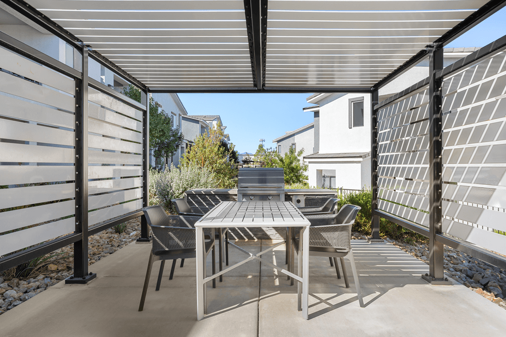 A patio with a table and chairs under a roof.