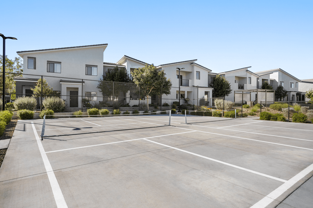 A parking lot in front of a row of modern houses.