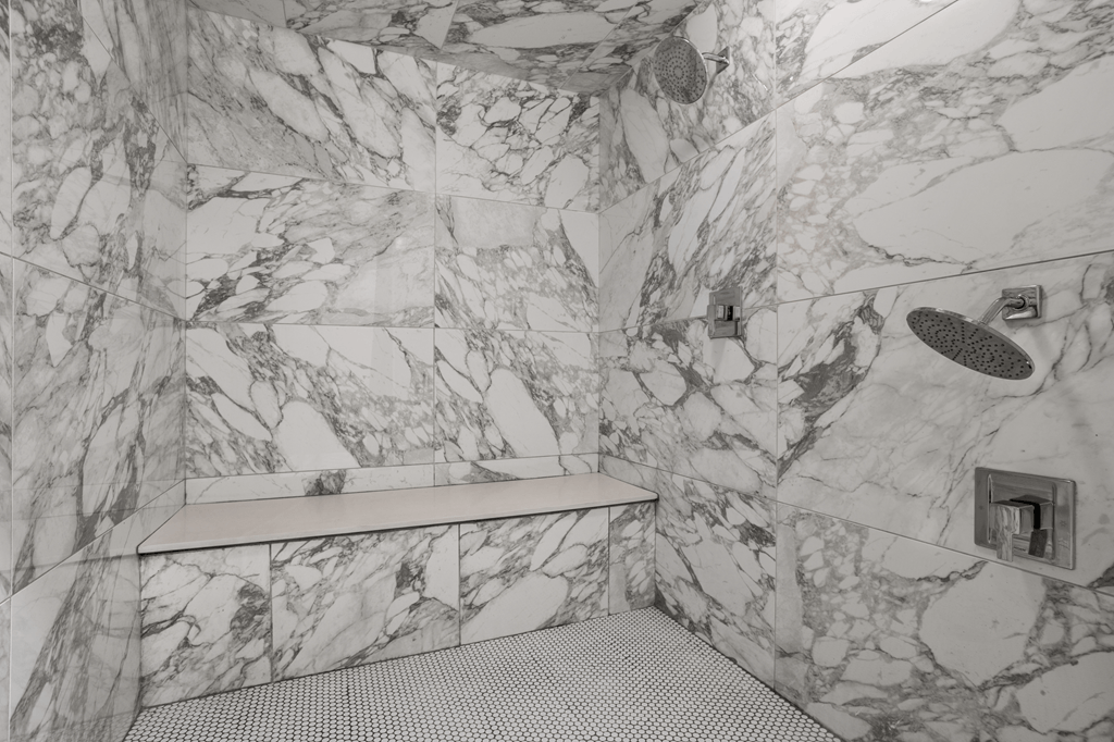 A bathroom with marble walls and a marble sink.