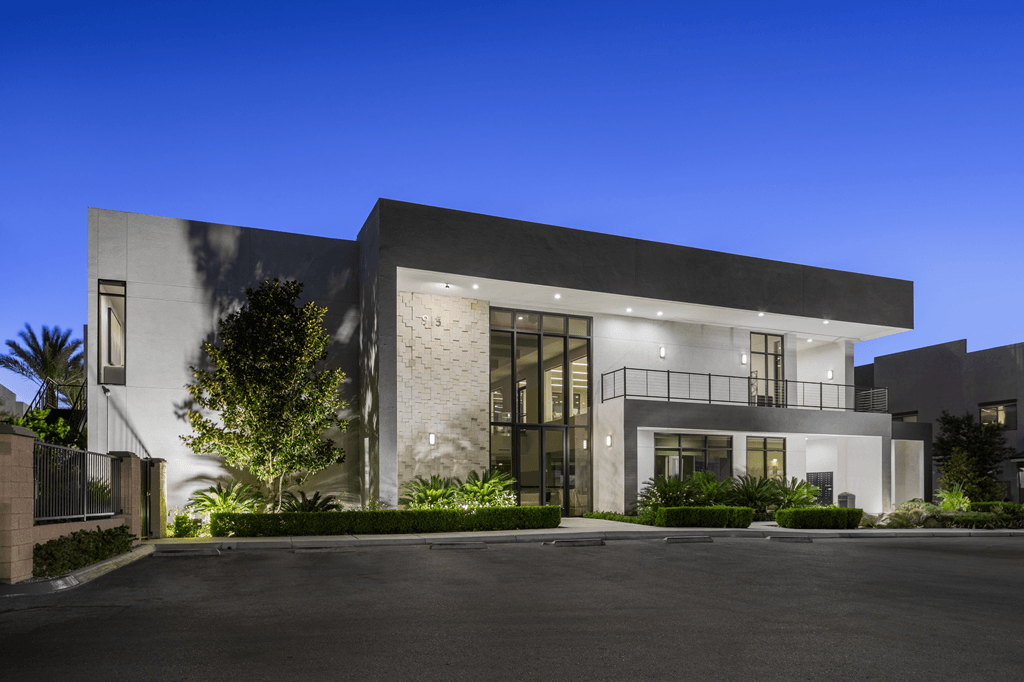 A modern house with a black gate and a driveway.