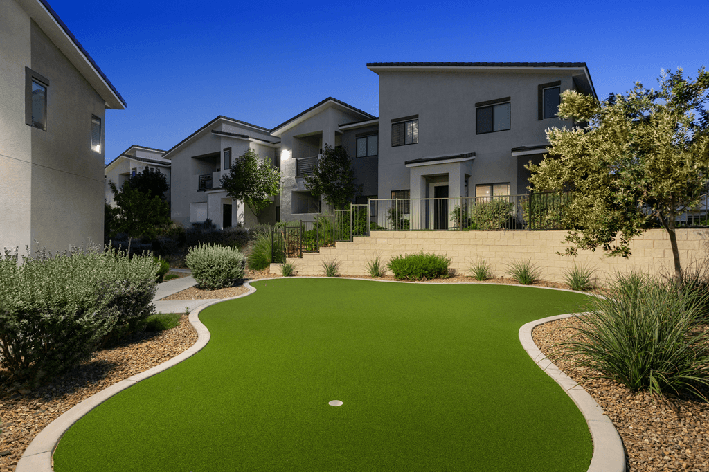 A residential area with a green lawn and a building in the background.