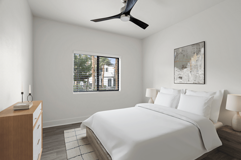 A bedroom with a large bed and a ceiling fan.