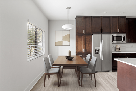 A modern kitchen with a dining table and chairs.