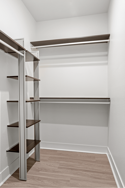 A white room with a shelving unit and a white wall.