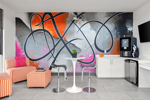 A modern living room with a large abstract painting on the wall.