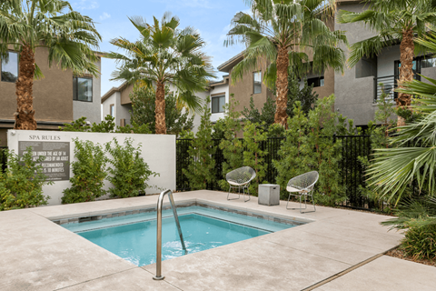 A pool surrounded by palm trees and chairs.