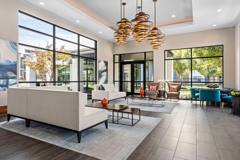 A modern living room with a large white sofa and a glass door.