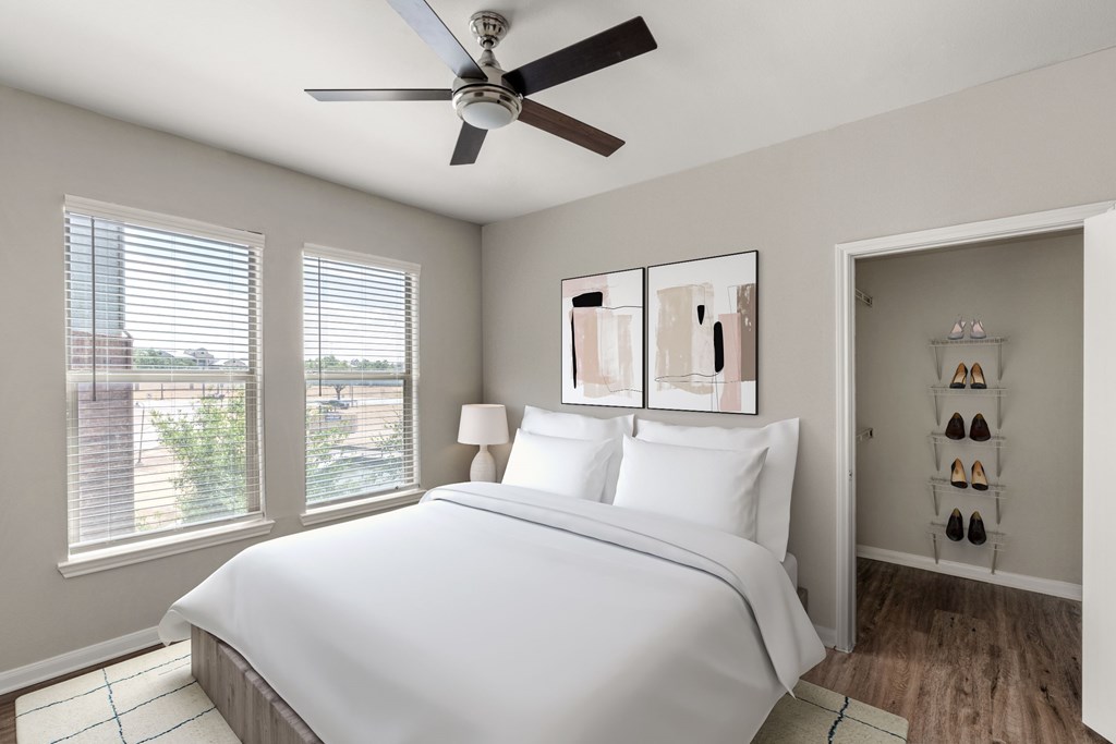 A bedroom with a large bed and a ceiling fan.