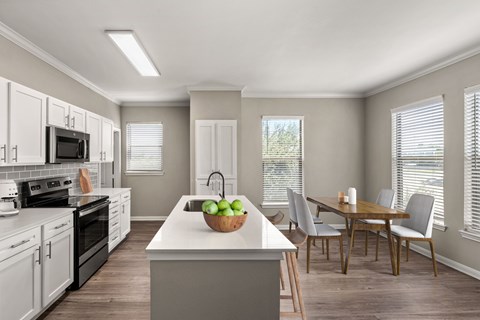 A kitchen with a table and chairs.