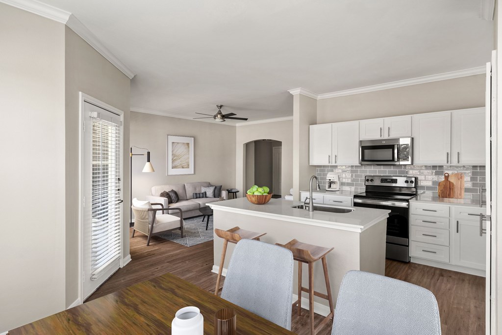 A kitchen with a white countertop and a white ceiling fan.