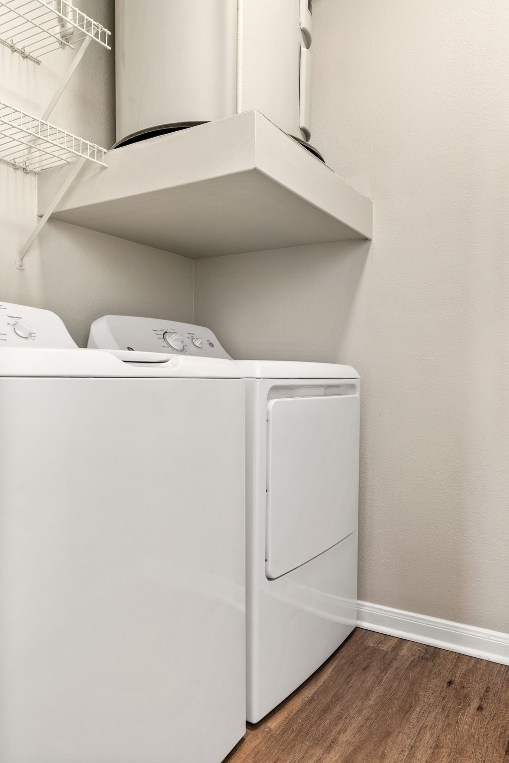 A white dryer and washer in a small laundry room.