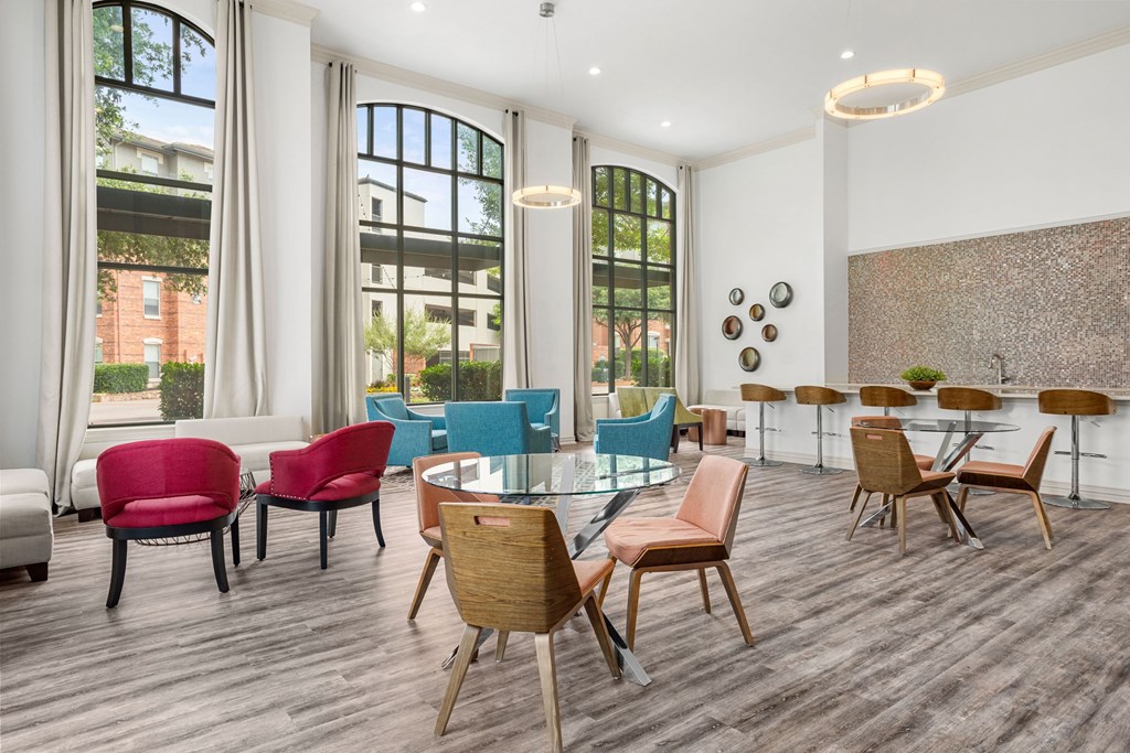 A room with a long table and chairs in front of a window.