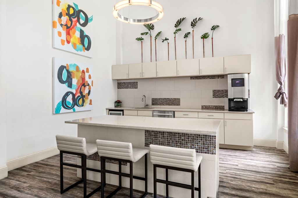 A kitchen with a white counter and bar stools.