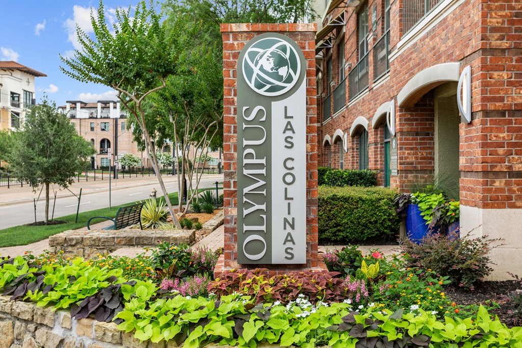 A sign that says Las Colinas in front of a building.