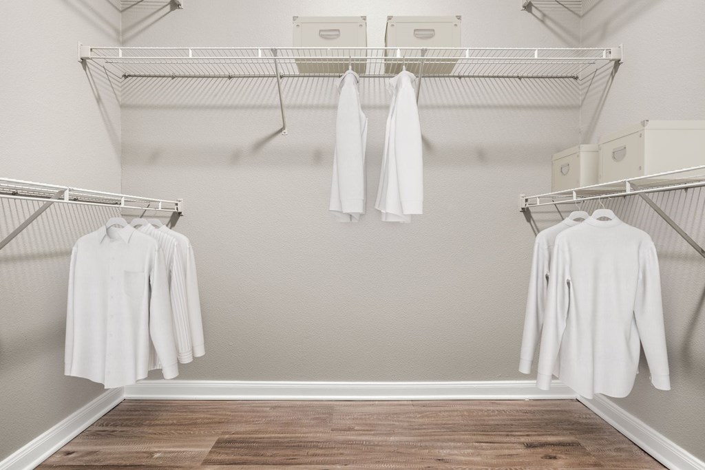A white shirt is hanging on a clothes rack in a room.
